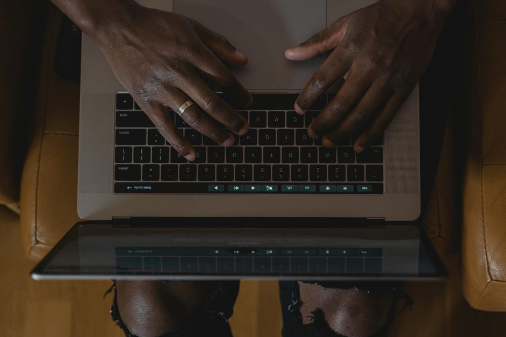 Overhead shot of hands typing on a laptop, showcasing modern technology use.